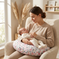 Maman berçant bébé endormi sur le coussin d'allaitement Papillon Duo motif fleurs roses